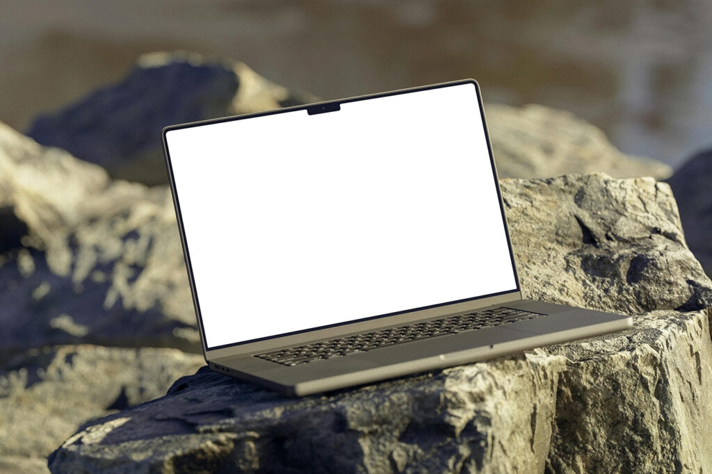 Free MacBook on Rock Mockup - mockupbee